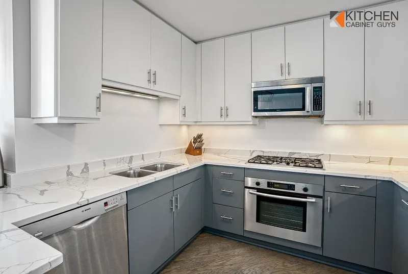 White upper cabinets above gray base units with new doors and drawer fronts