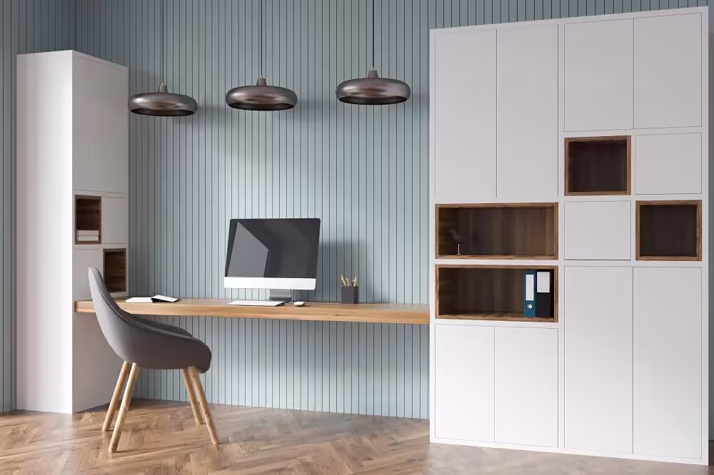 Home office with blue fluted wall panelling and white storage units
