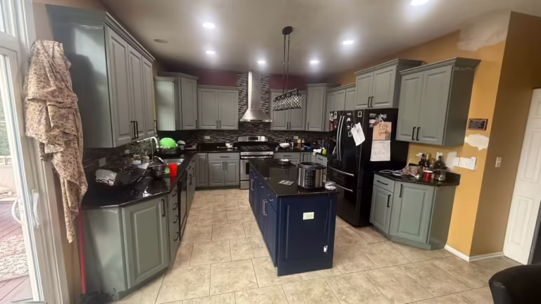 Sage gray raised panel cabinets and a navy island after refacing the maple kitchen