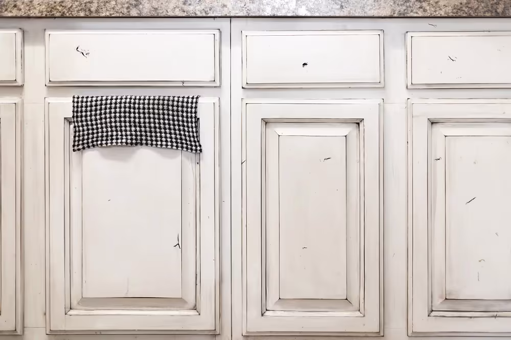 White cabinet doors with the finish peeling and chipping away
