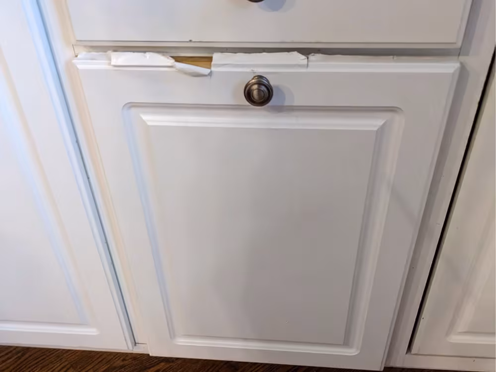 Peeling thermofoil around the knob of a white cabinet door