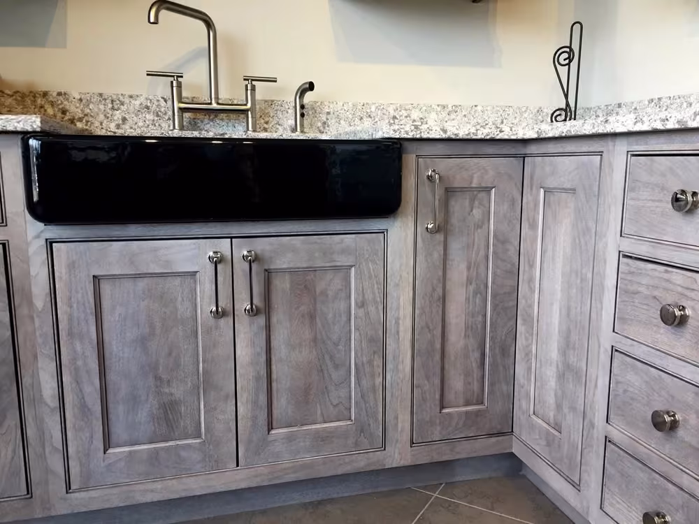 Gray weathered Shaker cabinets with a black farmhouse sink
