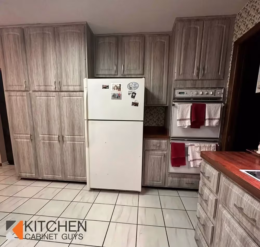 Gray wood-structure cabinets and a white refrigerator in Batavia