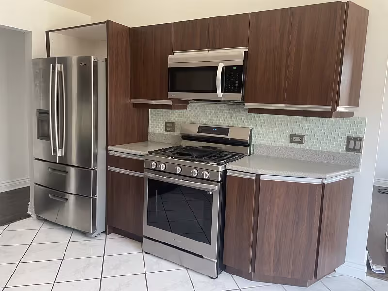 Dark woodgrain cabinets and a stainless range in a Wheeling kitchen before refacing