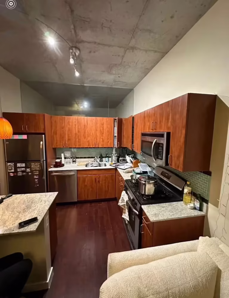 Dark cherry cabinets in a downtown Chicago loft kitchen before thermofoil repair