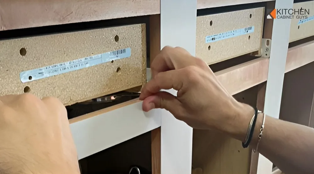 Hands measuring cabinet box frames during an on-site refacing