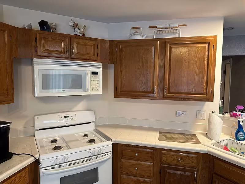 Golden oak cabinets and white appliances in a Bartlett kitchen before refacing