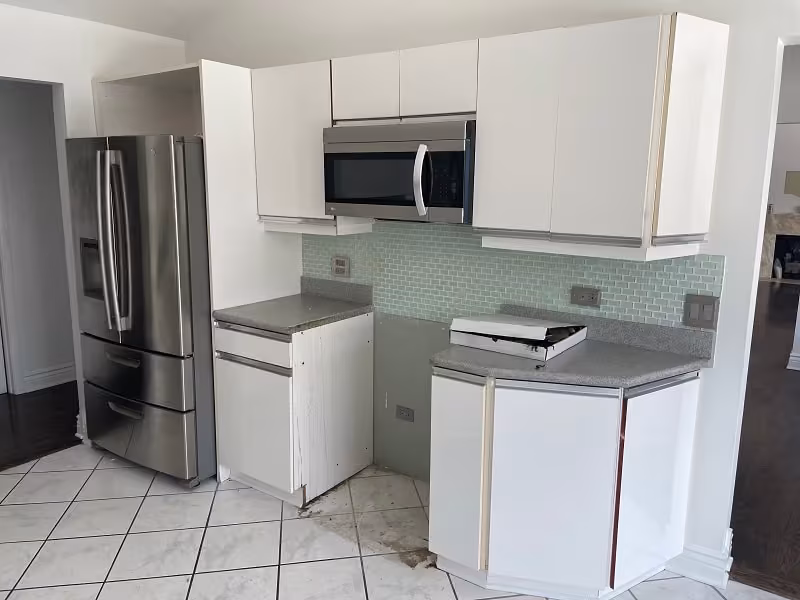 White refaced cabinets and a green tile backsplash in the Wheeling kitchen