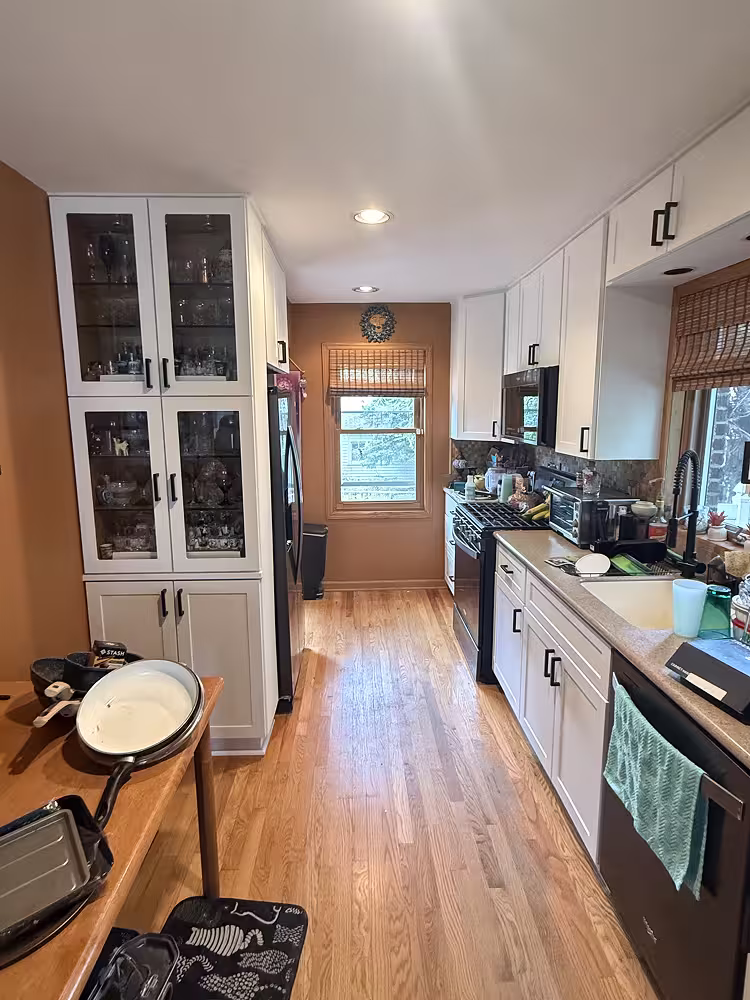 White refaced cabinets with glass-front uppers brightening the former oak kitchen