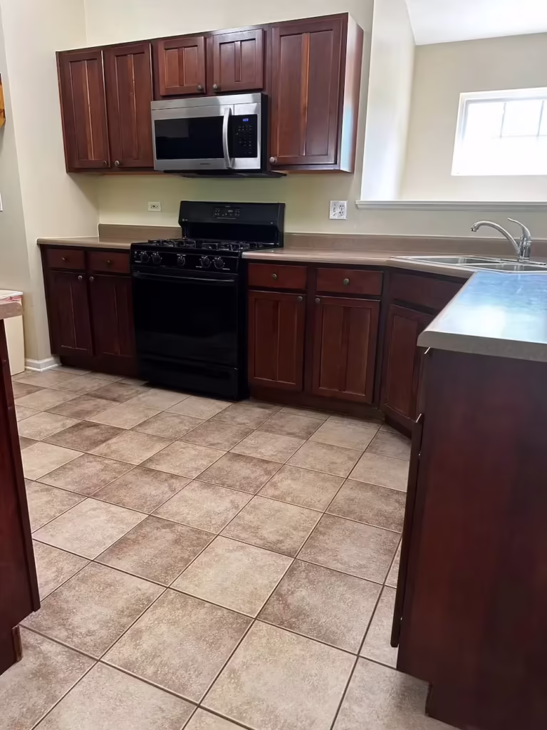 Dark cherry cabinets and tile floor in the South Elgin kitchen before its refacing
