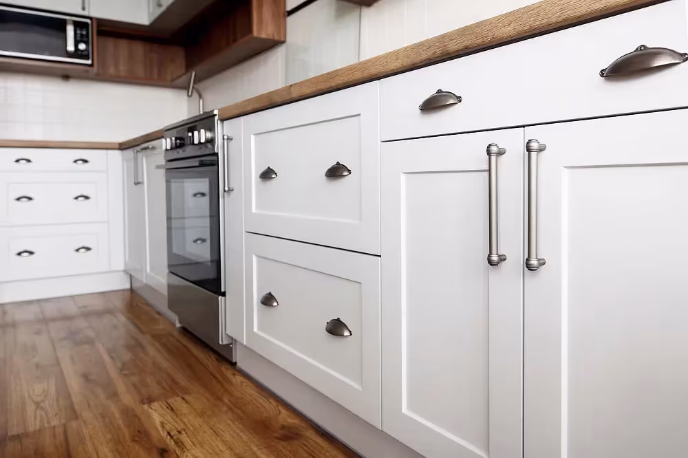 White Shaker drawers with chrome cup pulls and bar handles