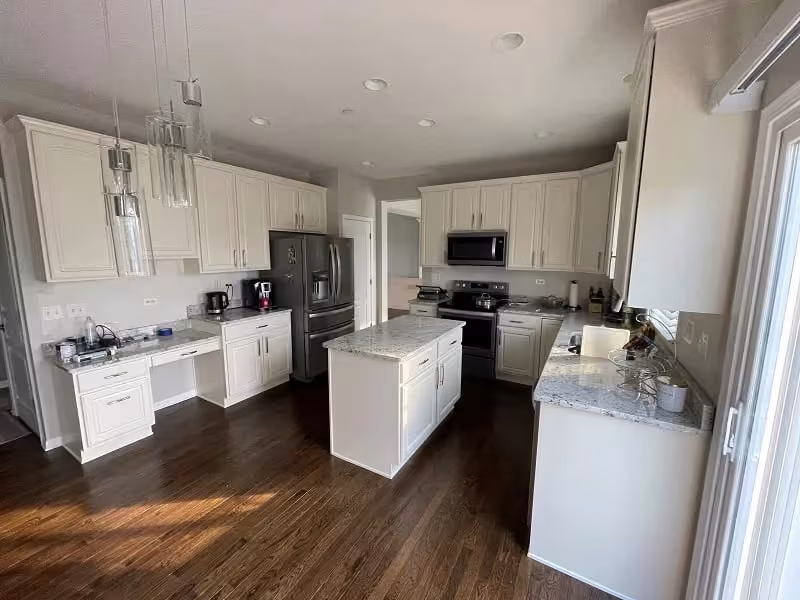 White kitchen with an island refaced for a commercial property
