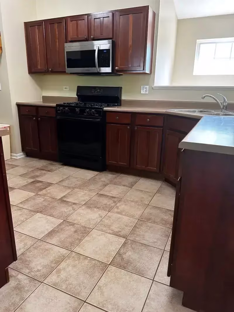 Dark cherry cabinets over tile flooring in South Elgin before refacing