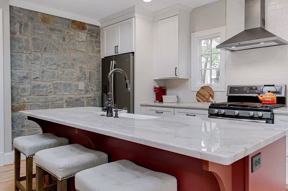 White marble island against a stone feature wall
