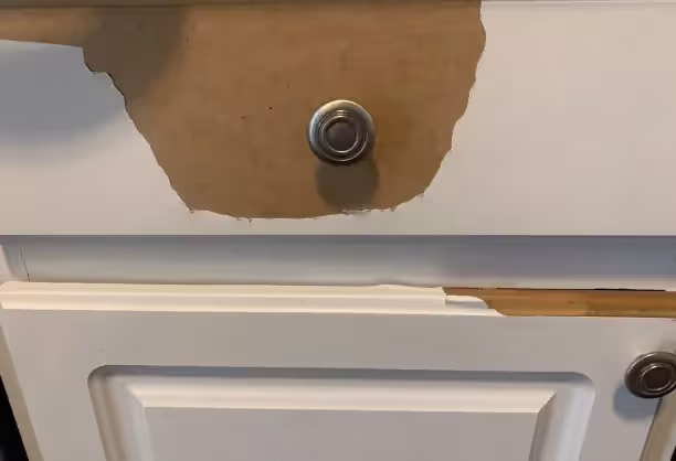 Damaged thermofoil exposing the MDF core of a cabinet door