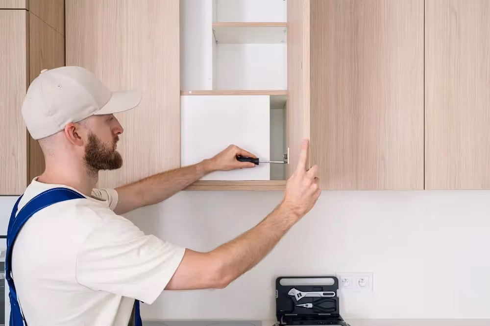 Technician fitting a light wood replacement cabinet door