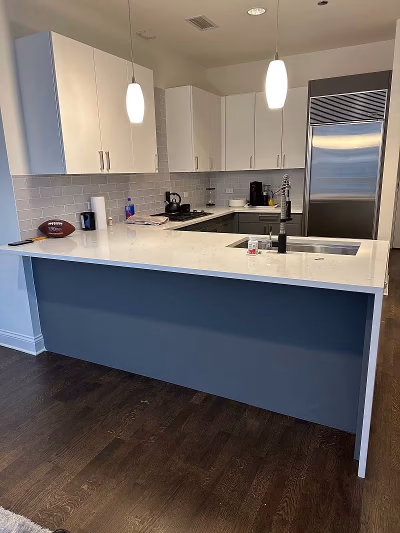White uppers above a navy peninsula after refacing the Chicago kitchen