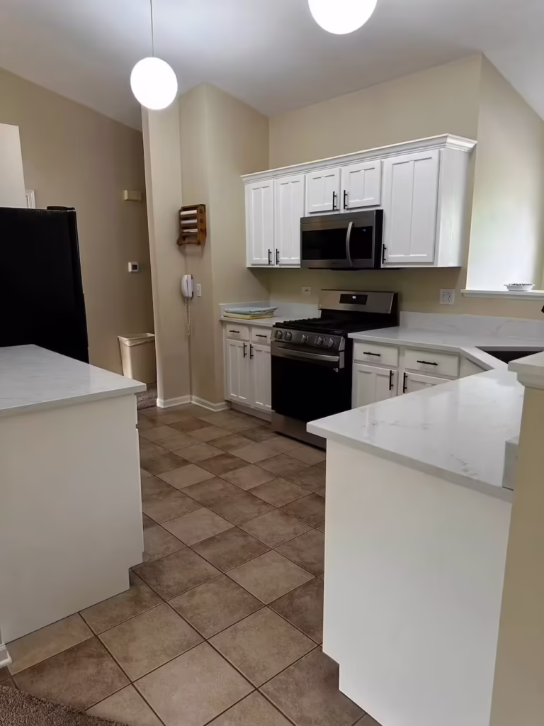 White refaced cabinets and quartz counters in the South Elgin kitchen
