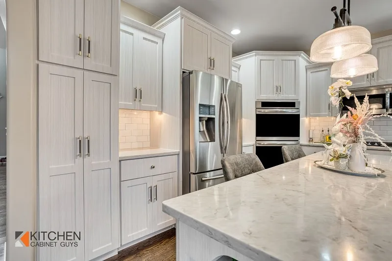 White Shaker cabinets and a marble island produced by cabinet refacing