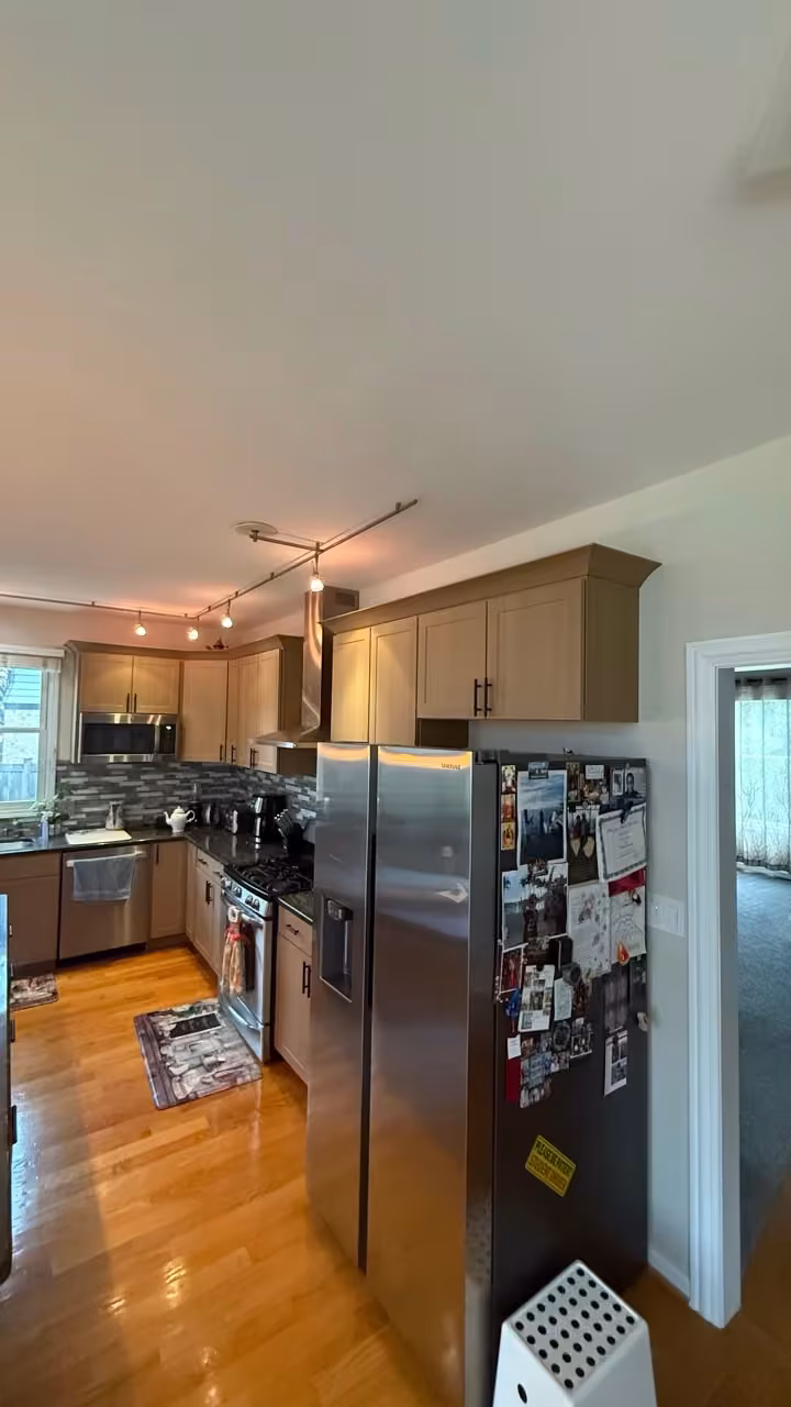 Beige Shaker cabinets seen from the hallway after the open-plan kitchen was refaced