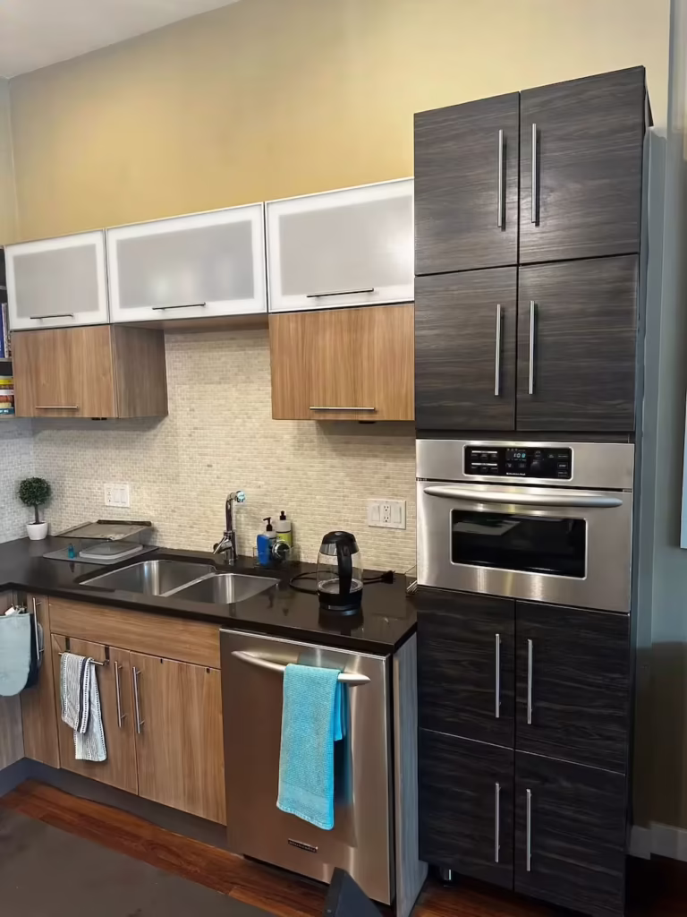 Two-tone Northbrook kitchen with dark woodgrain and white gloss doors before repair