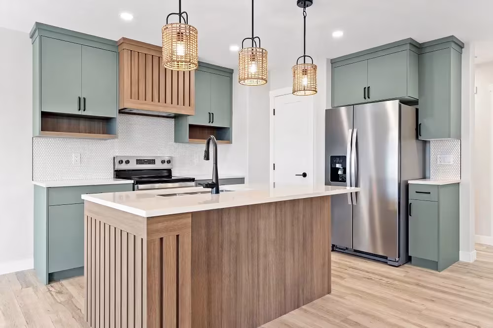 Sage green kitchen with a wood island and matching pendant lights