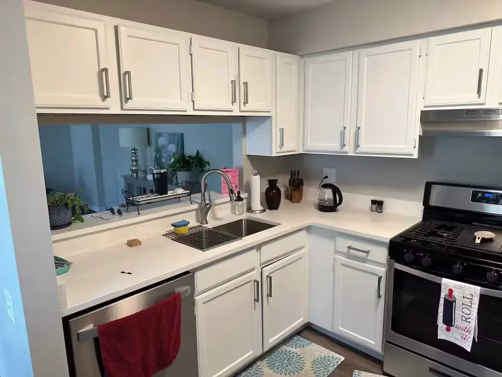 Cream cabinets with a teal backsplash in the Hoffman Estates kitchen before door replacement