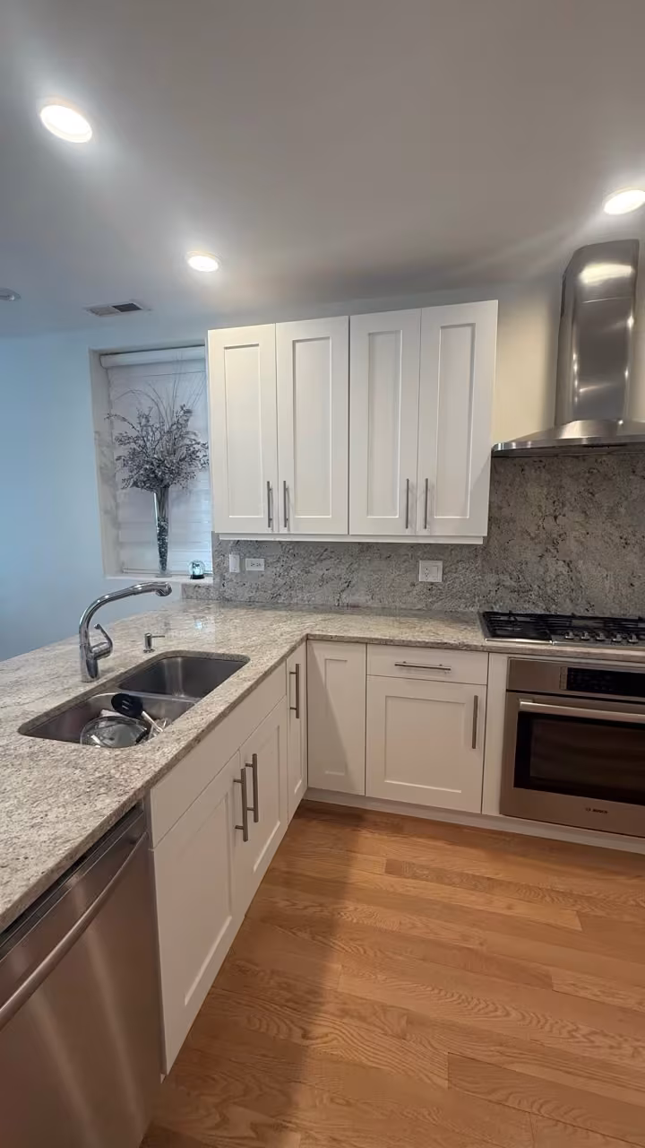 Cream-white cabinets and a stainless range after refacing the espresso kitchen