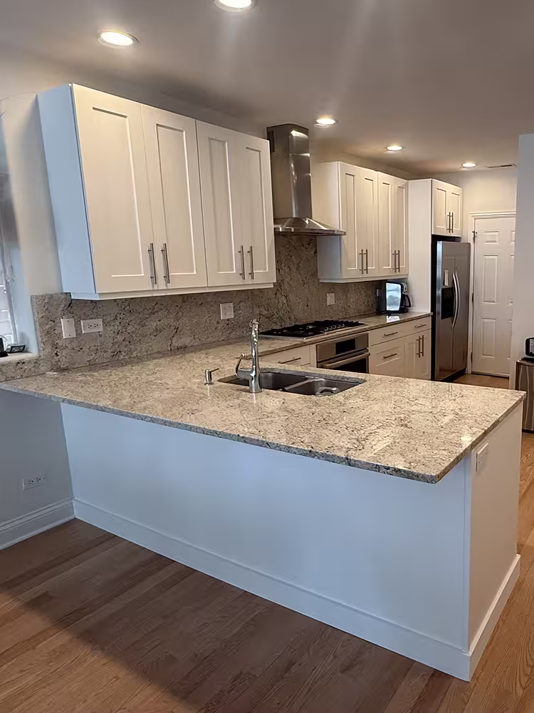 Cream-white refaced cabinets and range hood in place of the espresso fronts