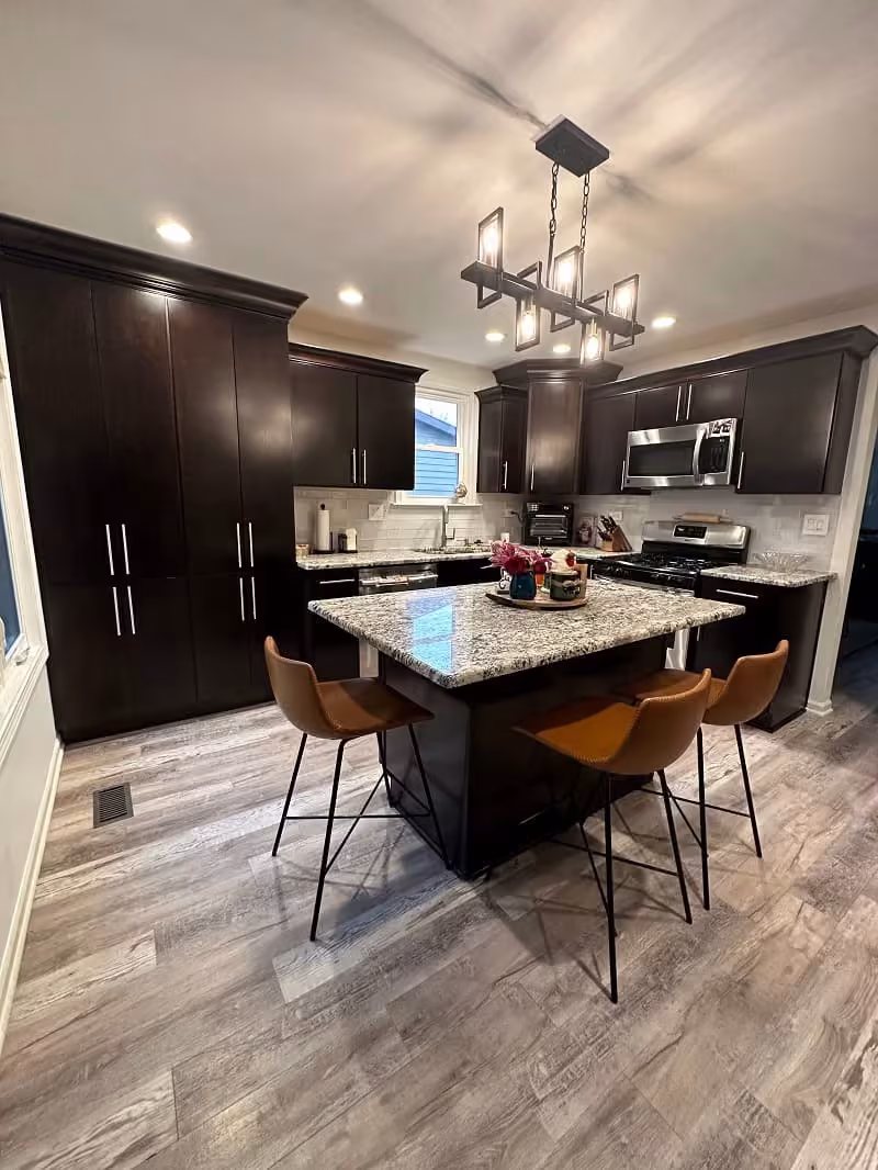 Dark espresso cabinets and island with a black chandelier in Bartlett before refacing