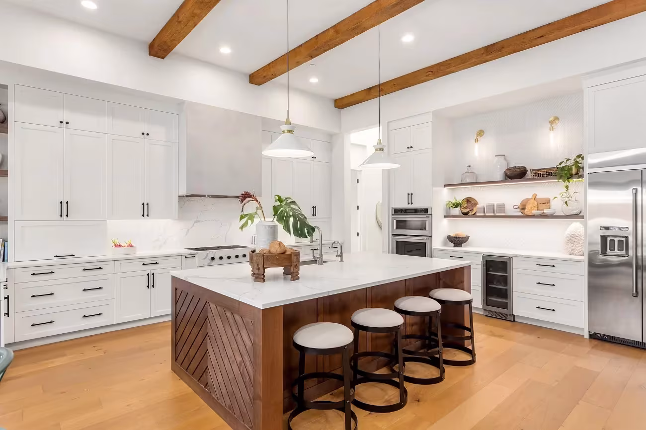 White Shaker cabinets and a walnut island under beams in an Aurora kitchen