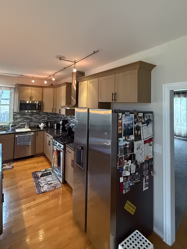 Beige linen Shaker doors coordinating with the dark granite island after refacing