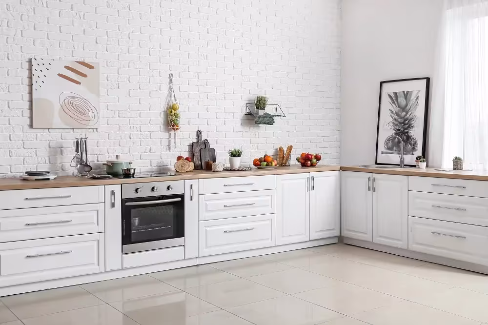 White kitchen with framed prints hung above the worktop