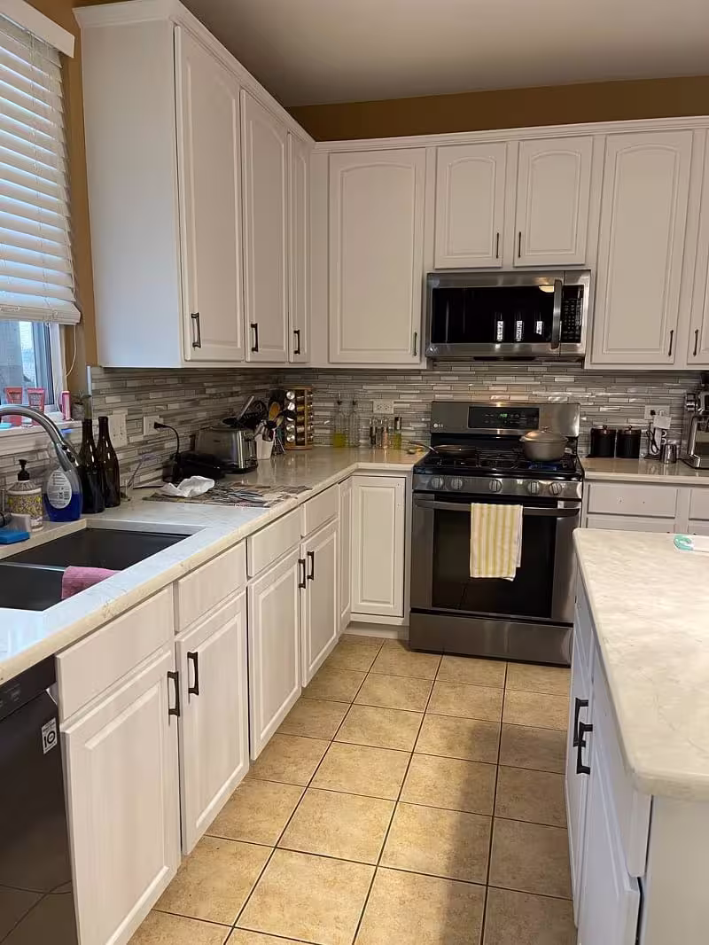 White refaced cabinets above the tile backsplash after the project