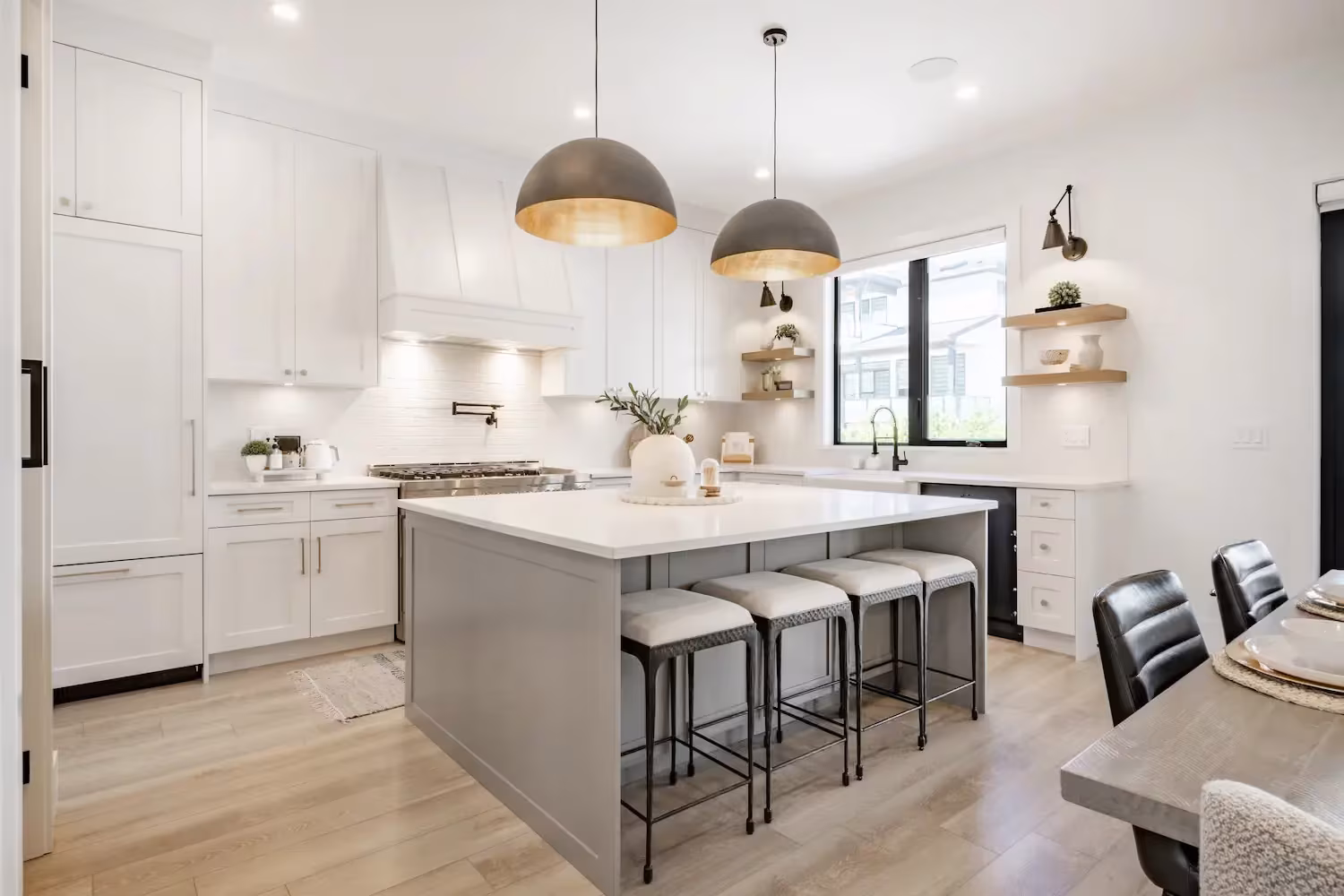 White kitchen with a gray island and dome pendants in an Algonquin home