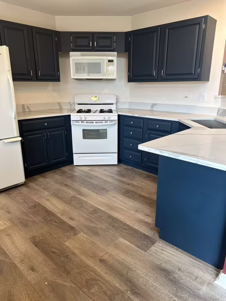 Dark navy upper and lower cabinets after the Bartlett budget refacing