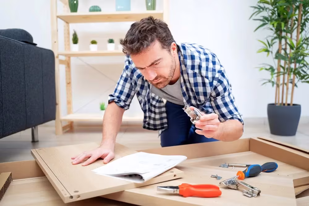 Man assembling flat-pack cabinet parts from the instructions