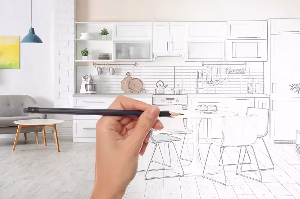Hand sketching a kitchen layout over a printed view of the finished room