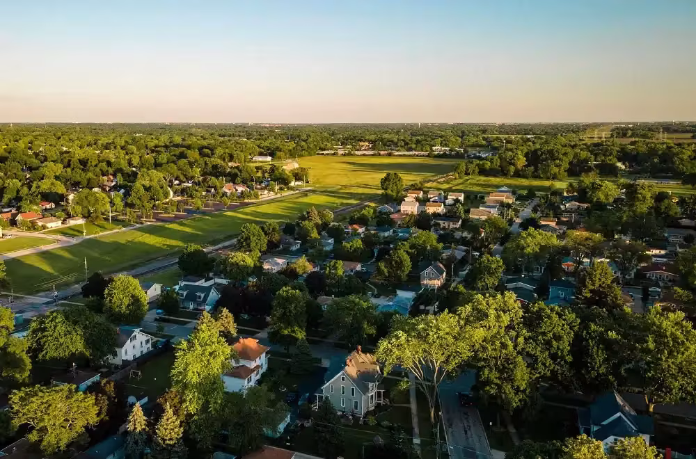Aerial view of parkland and homes around West Chicago at dusk